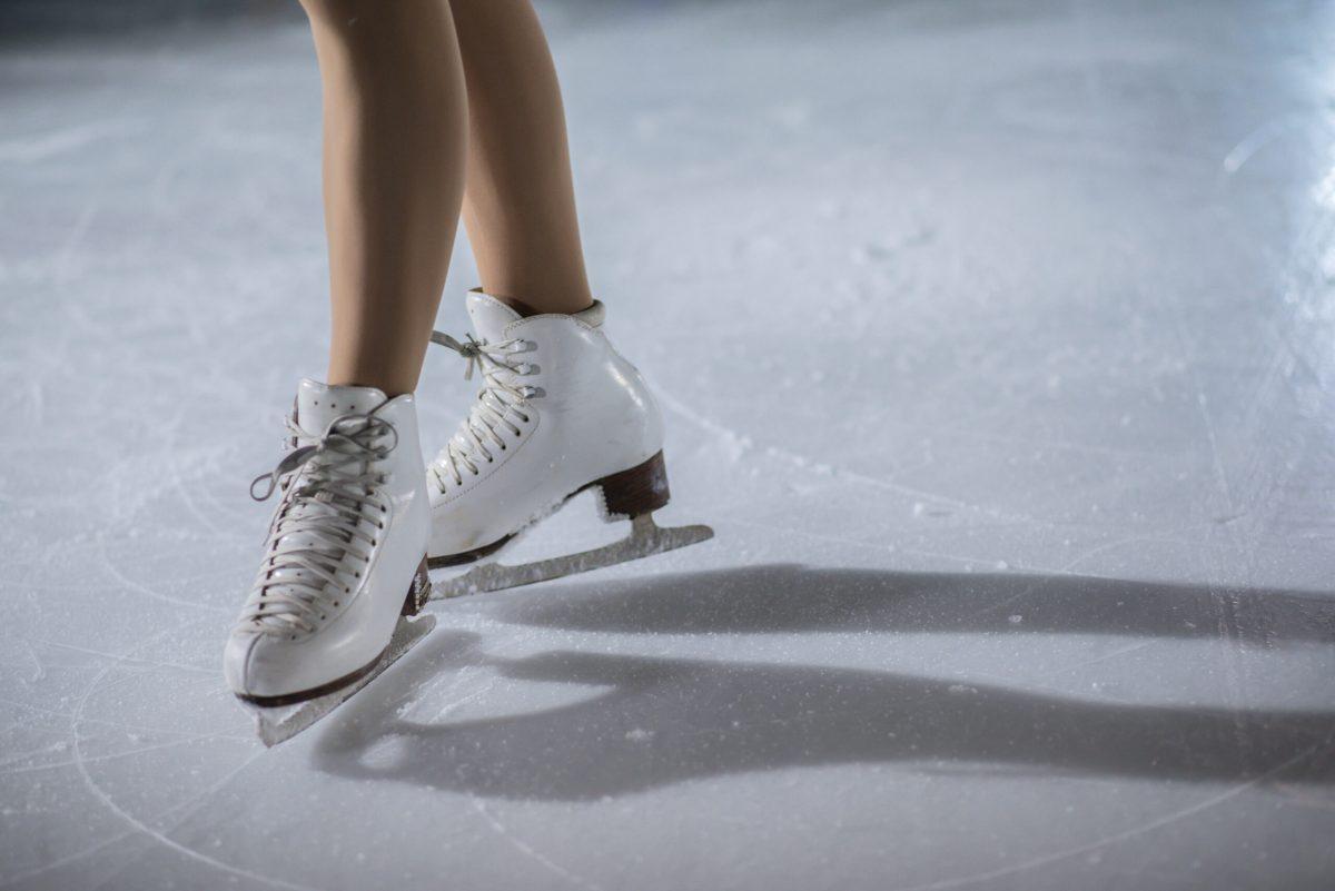 Gorgeous ice skates on the ice rink on a young girl's feet.