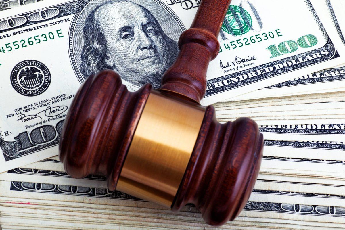 Gavel over hundred dollar bills. Financial settlement.